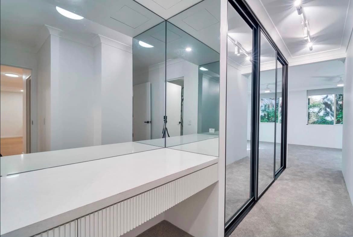 Walk-in dressing room with fluted vanity and mirrored sliding doors
